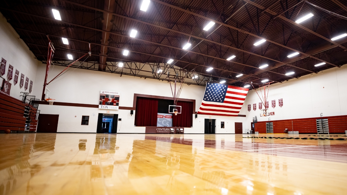 Clarksville Christian School gymnasium with basketball court, bleachers and American flag