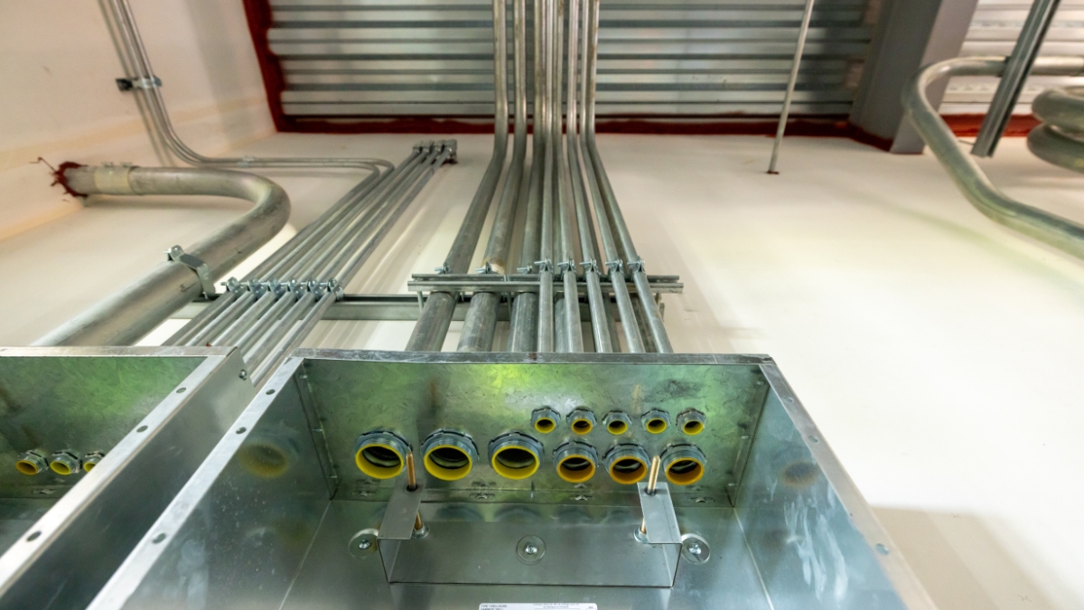 Metal electrical conduit entering a commercial electrical panel during construction
