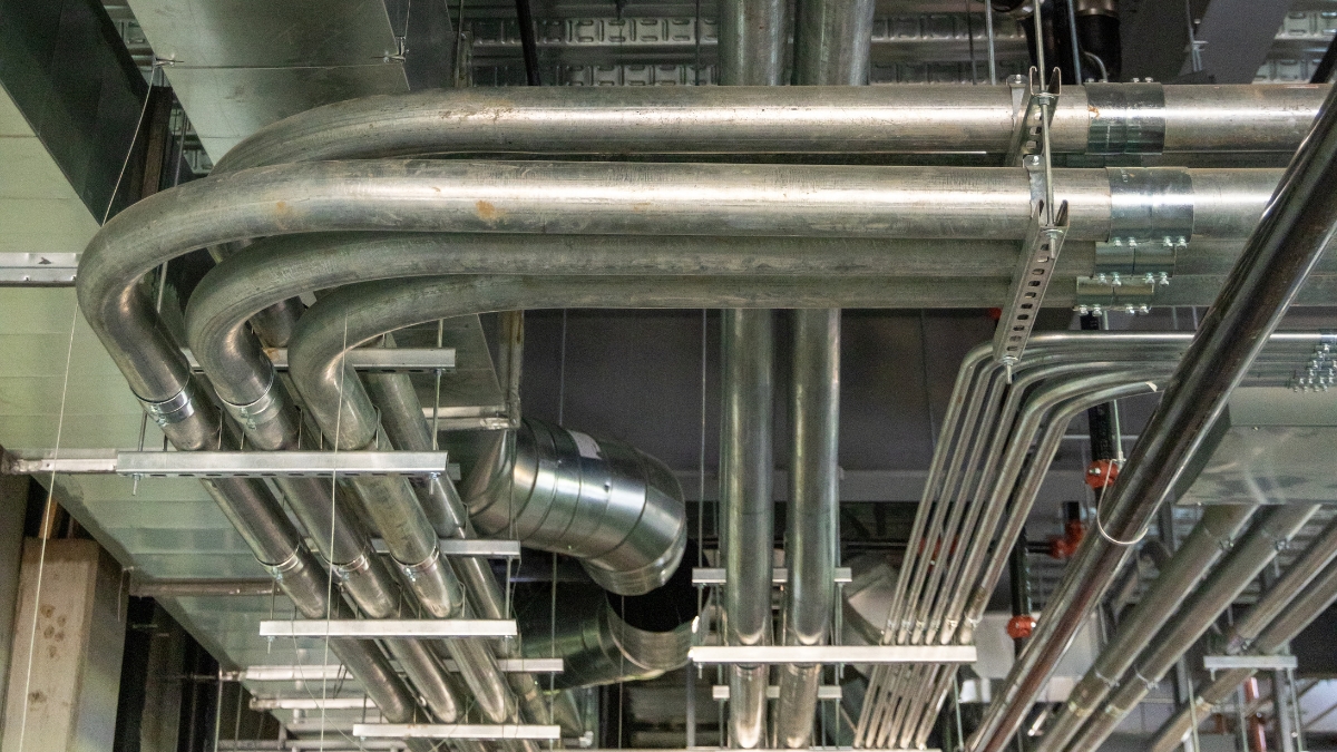 Organized metal conduit runs installed alongside commercial HVAC ductwork