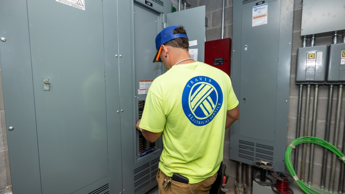 Travis Electrical Service electrician working inside a commercial electrical panel