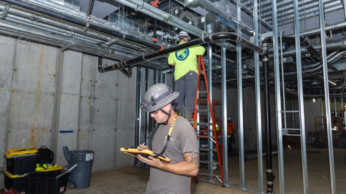 Metal conduit entering a commercial electrical panel during building construction