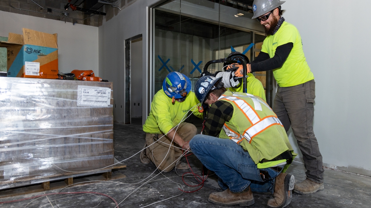 Commercial electricians pulling electrical wire during construction of Wyatt Johnson Subaru