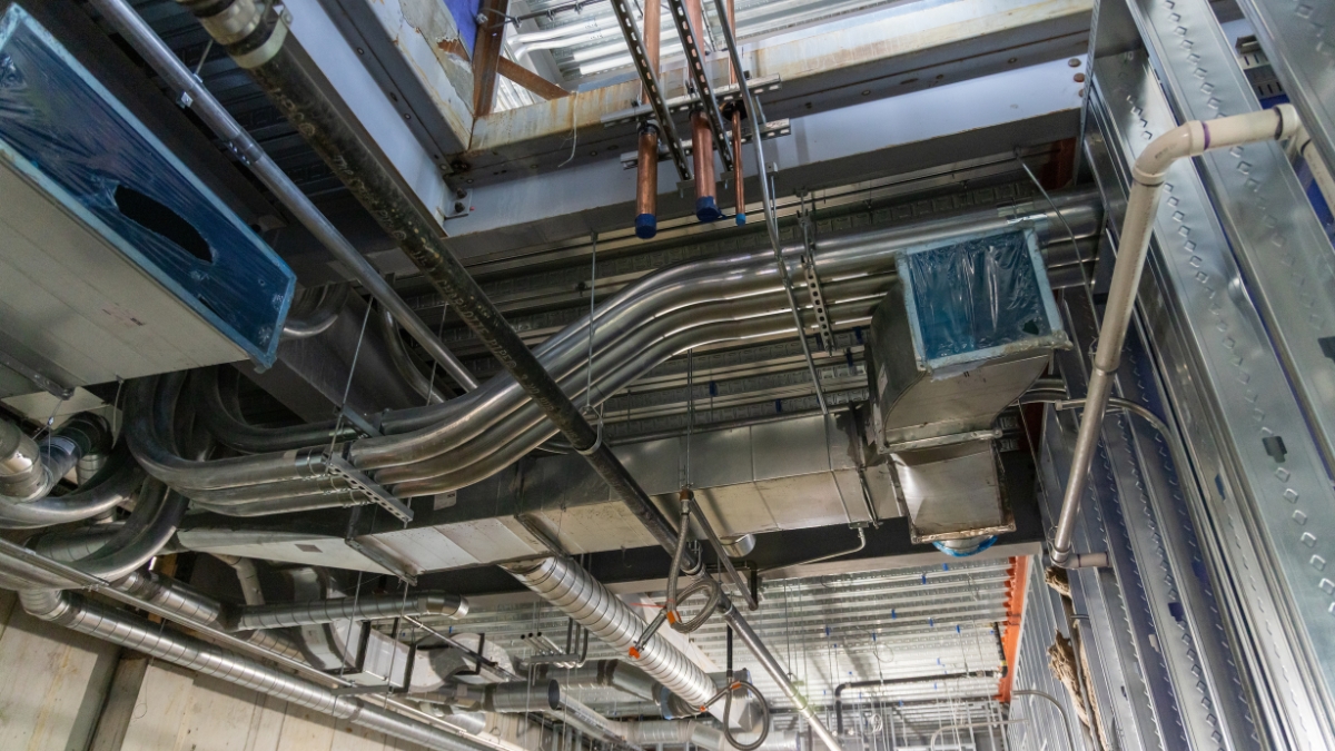 Electrician preparing metal conduit fittings during commercial construction