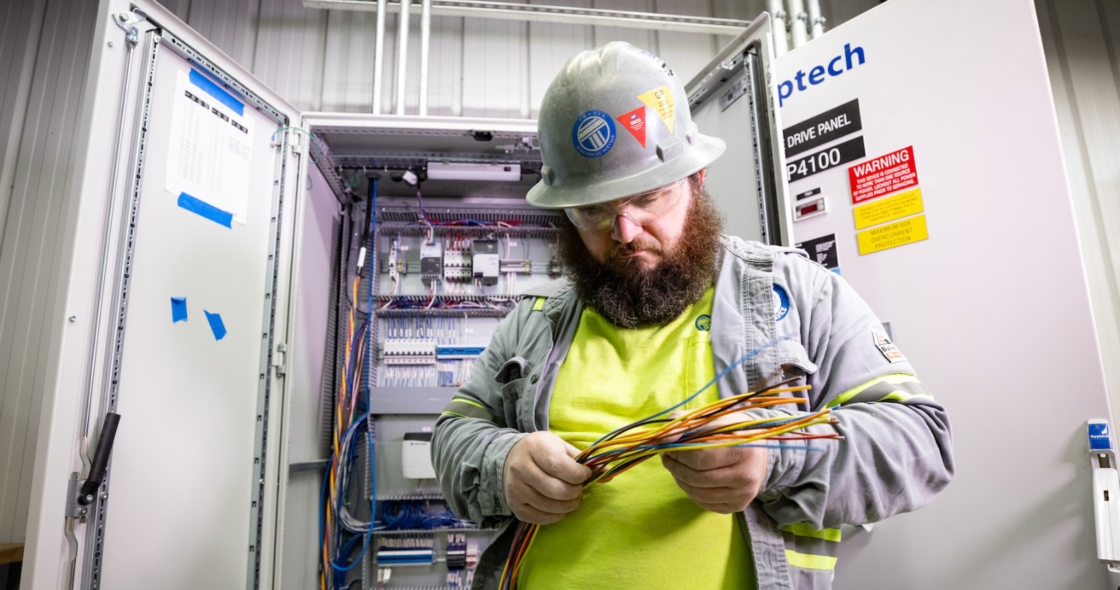 Electrician checking wires in industrial facility