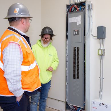 Electrician working on electrical panel in commercial facility