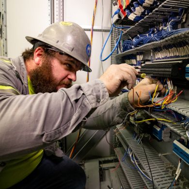 Electrician working with wires in an industrial facility