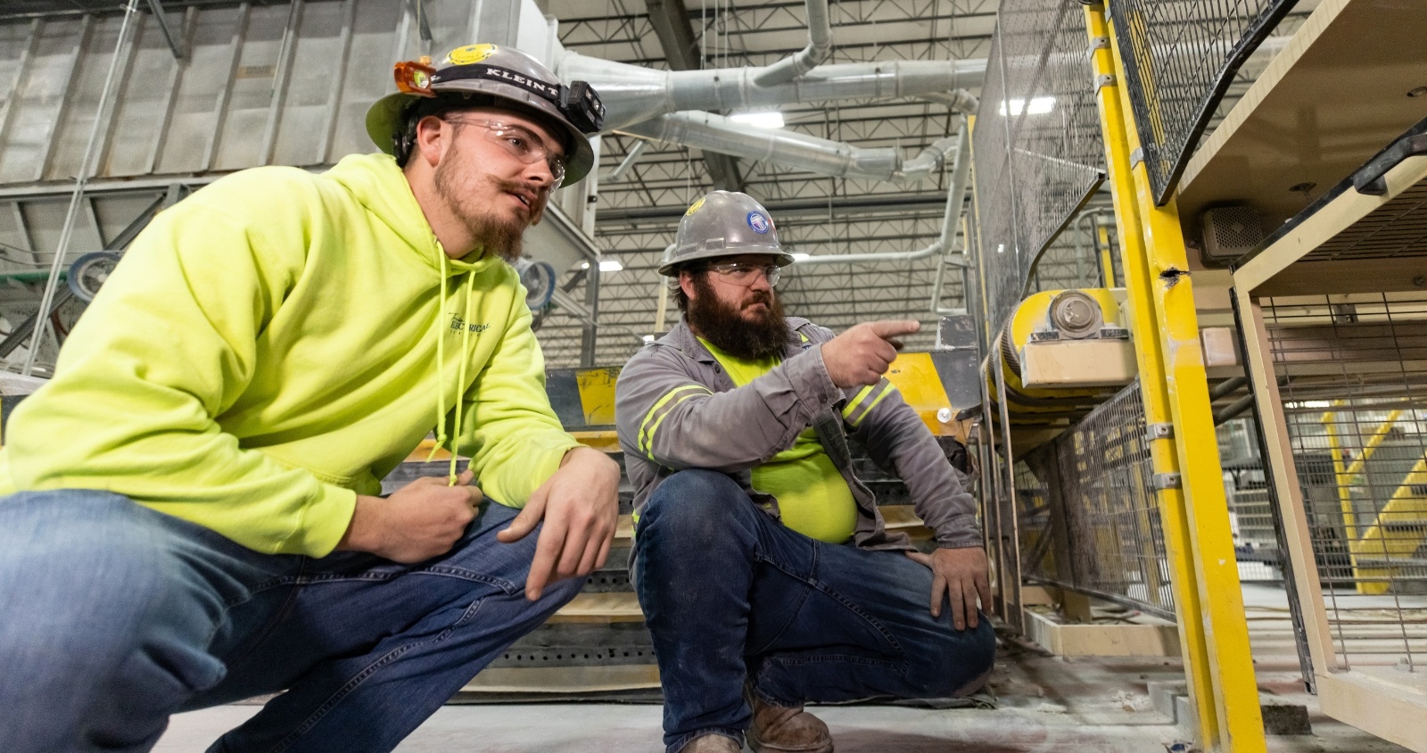 Electricians sitting on floor of industrial facility