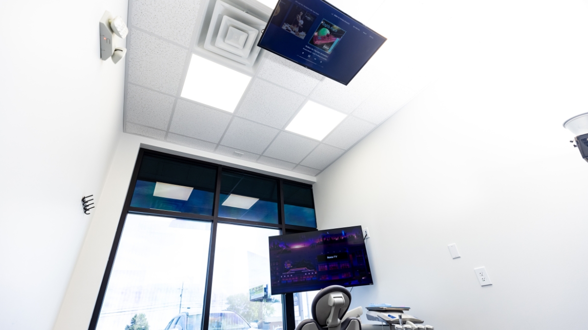 Patient view of a dental chair and ceiling-mounted television in an Ironwood Dental treatment room
