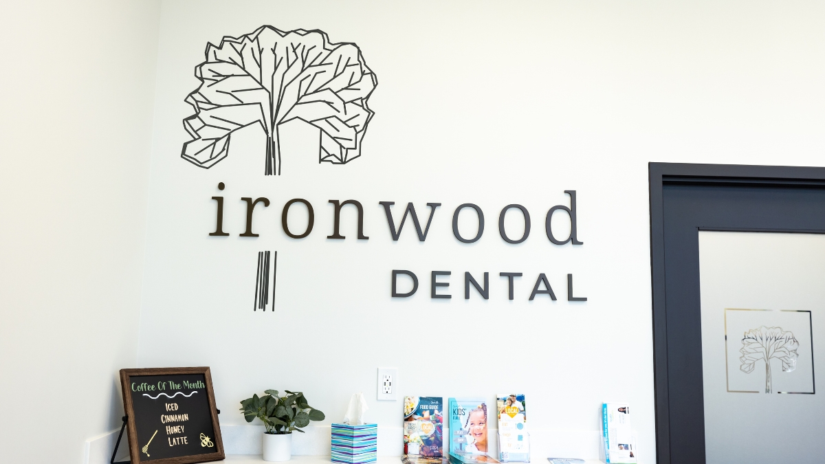 Ironwood Dental reception area with wall logo, informational brochures and coffee station