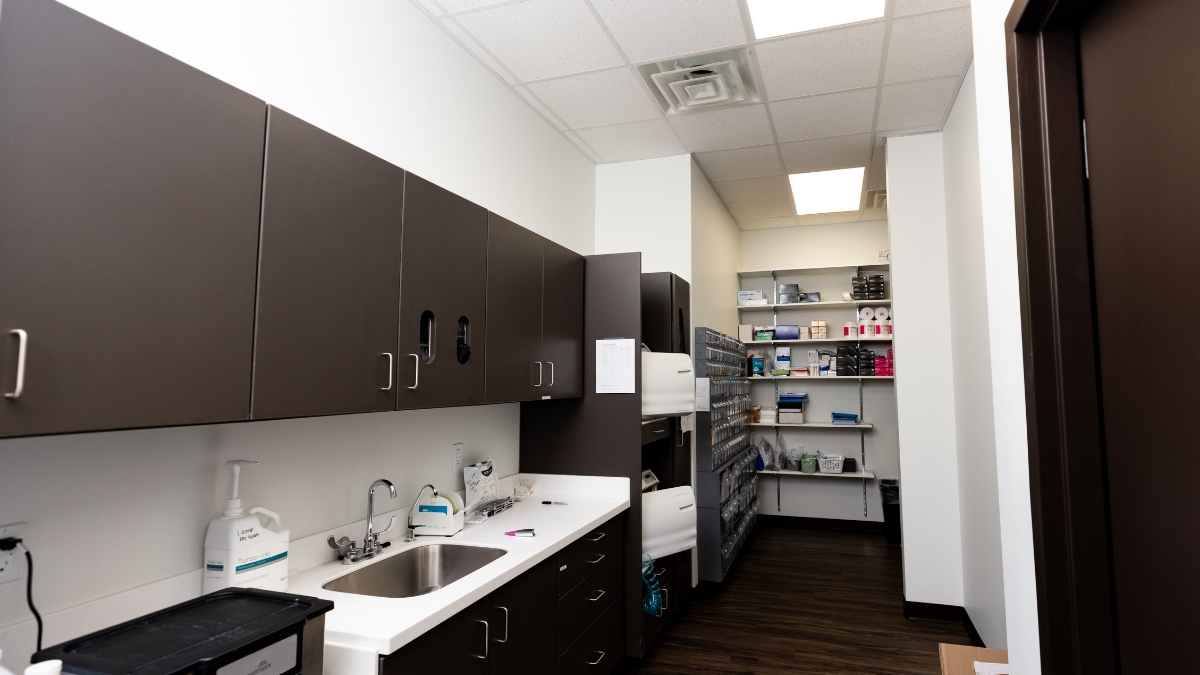 Sterilization and supply room at Ironwood Dental with cabinets, sink and organized dental materials