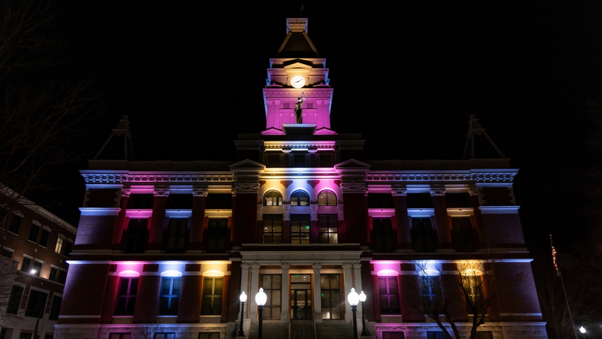 Montgomery County Courthouse illuminated with blue, pink and gold lights at night