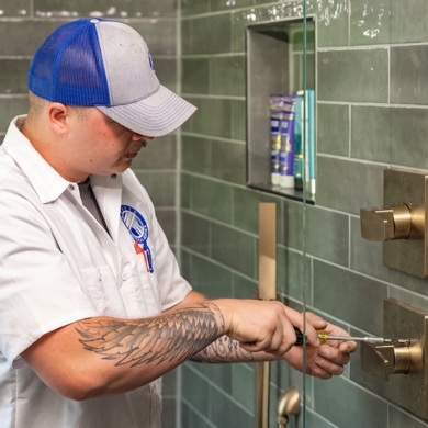 Plumber working on shower water handle