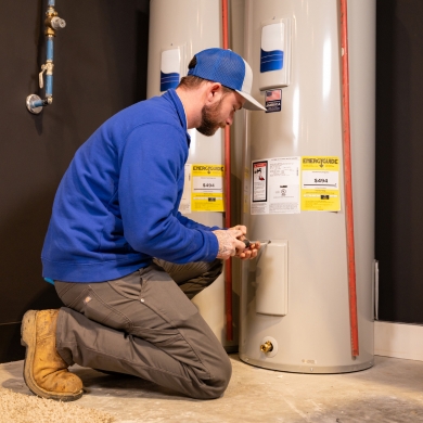 Plumber tightening panel on water heater