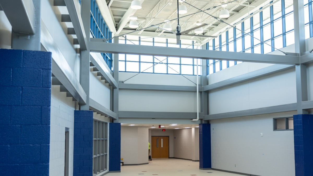 Modern school common area with blue columns, large windows and high ceilings