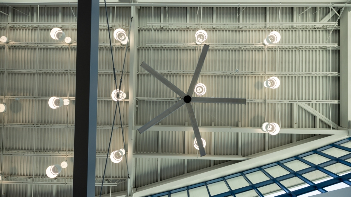 Large ceiling fan and pendant lighting installed in a modern school common area
