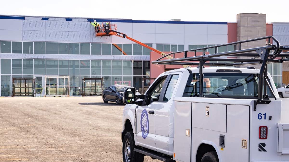 Wyatt Johnson Subaru building under construction with utility truck and workers on a lift