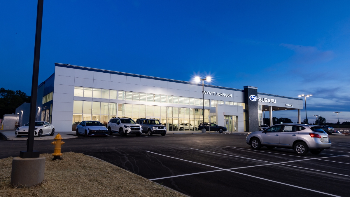 Wyatt Johnson Subaru dealership illuminated at night with vehicles outside the showroom