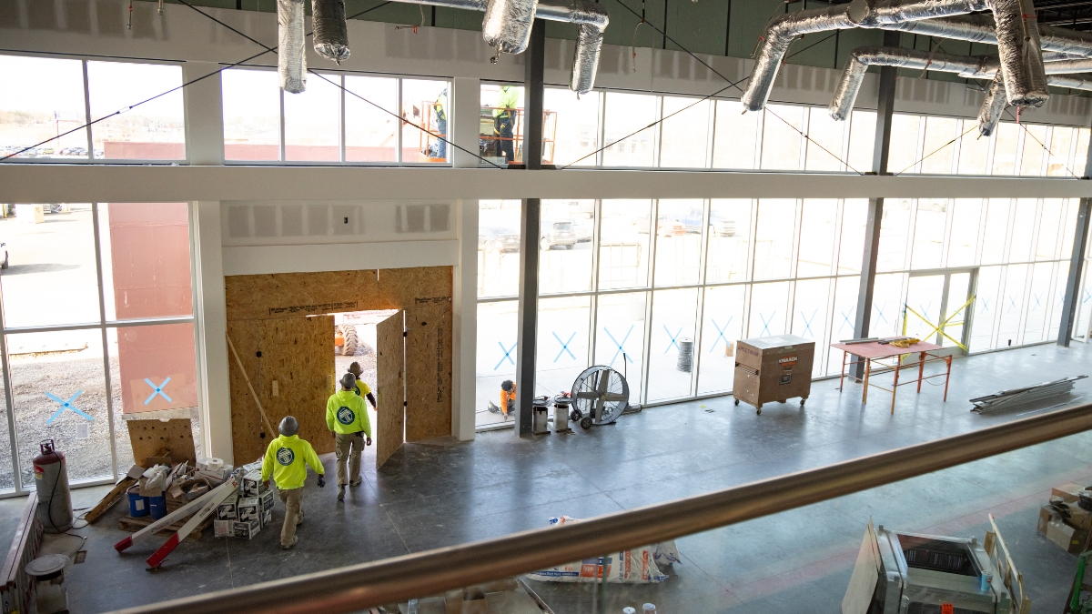 Interior construction of the Wyatt Johnson Subaru showroom with large windows, ductwork and workers