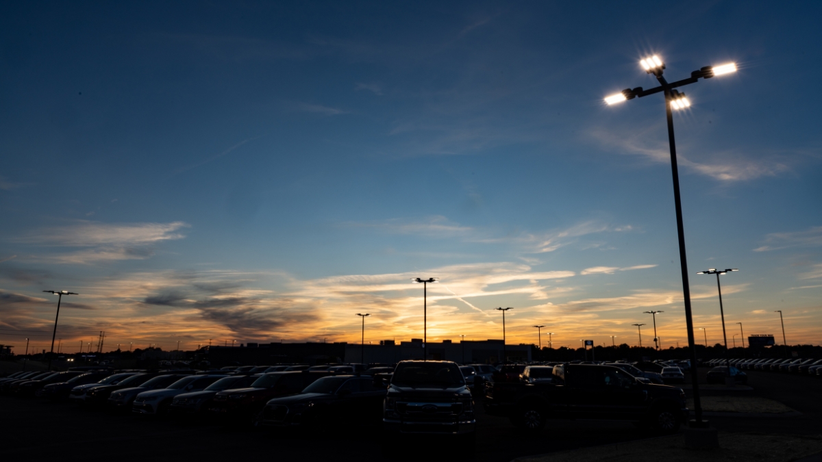 Vehicle lot at Wyatt Johnson Subaru under illuminated parking lights at sunset